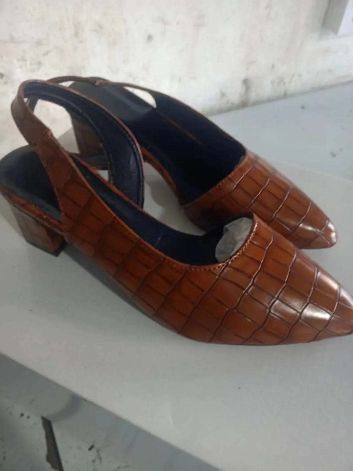 Side view of brown croc-effect slingbacks with dark insoles and block heels on a white surface 9