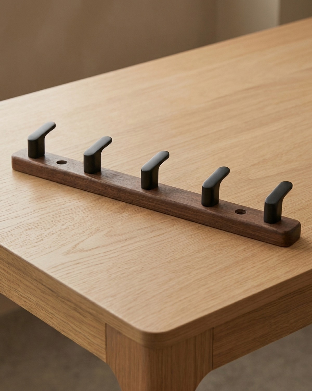 Five-hook version lying on an oak table, with two screw holes visible along the board 8