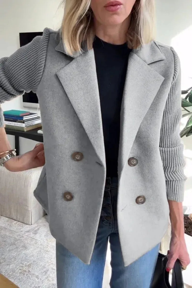 Close-up of grey double-breasted jacket on model, showing lapels, horn-style buttons and ribbed sleeves 9