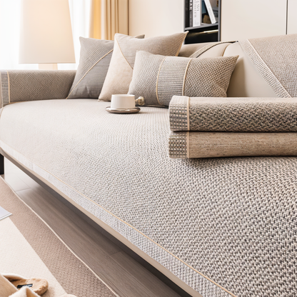 Beige woven sofa cover on the seat with two folded covers stacked on the right, showing the textured weave up close. 4