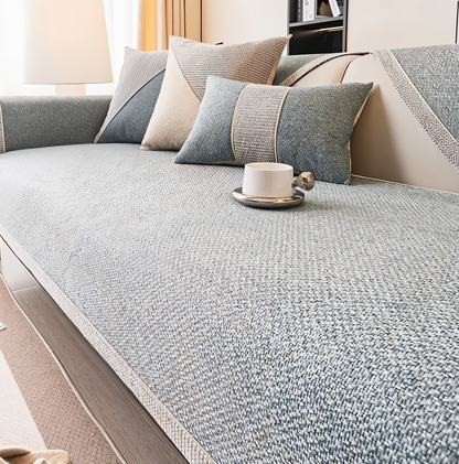 Grey version of the woven sofa cover on the seat and armrest, with grey cushions and a white cup on top. 6