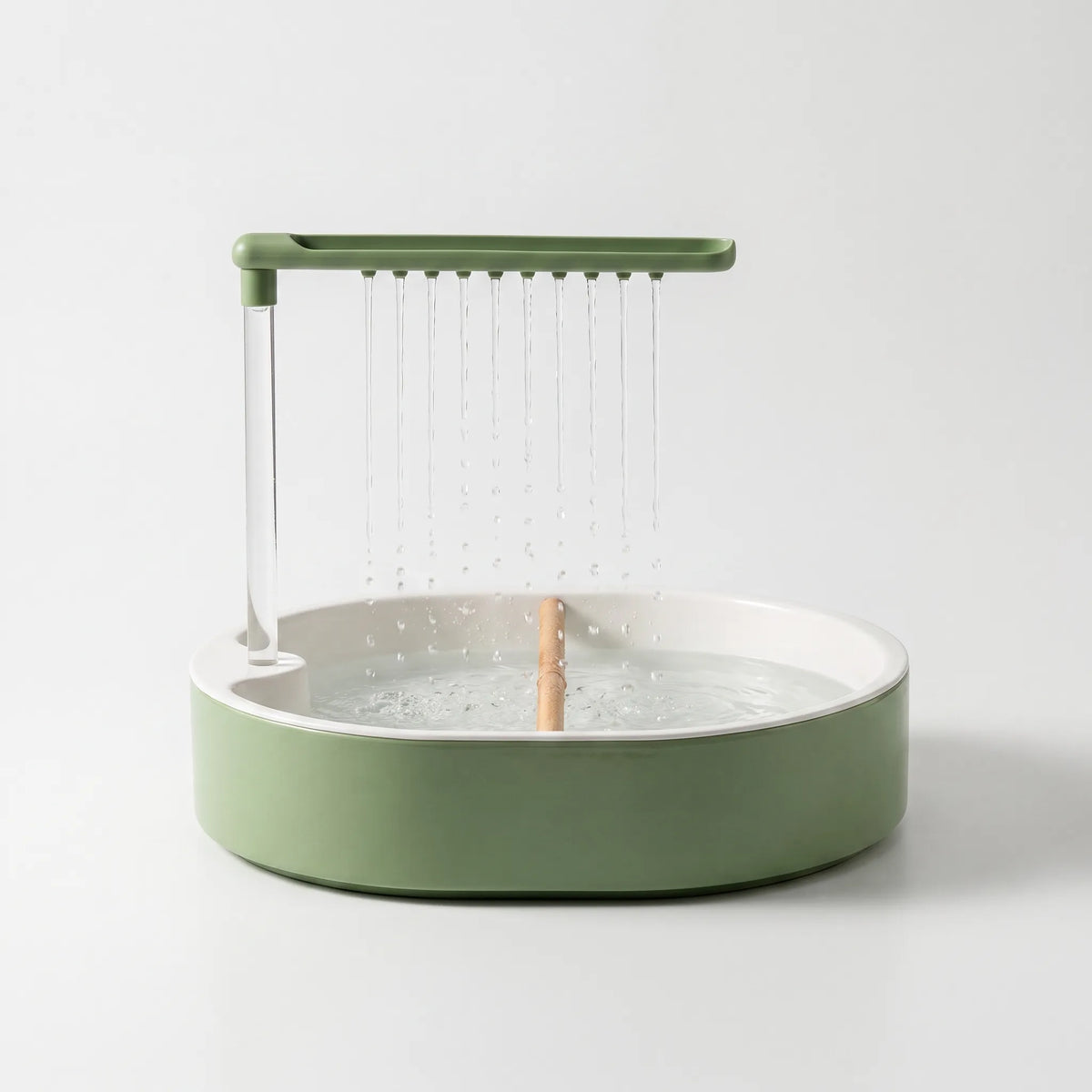 Front view on a plain white background of a green bath with a white inner basin, wooden perch and water falling from the overhead shower bar. 1