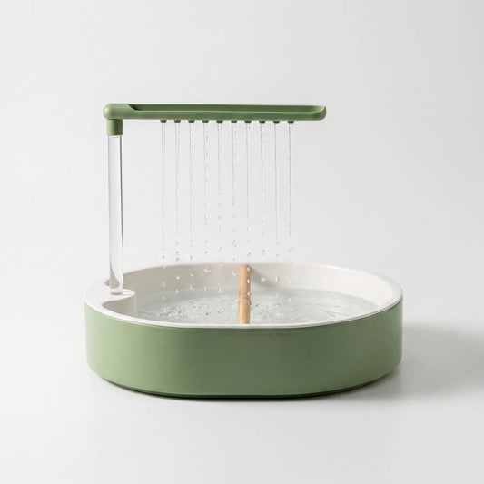 Front view on a plain white background of a green bath with a white inner basin, wooden perch and water falling from the overhead shower bar. 1