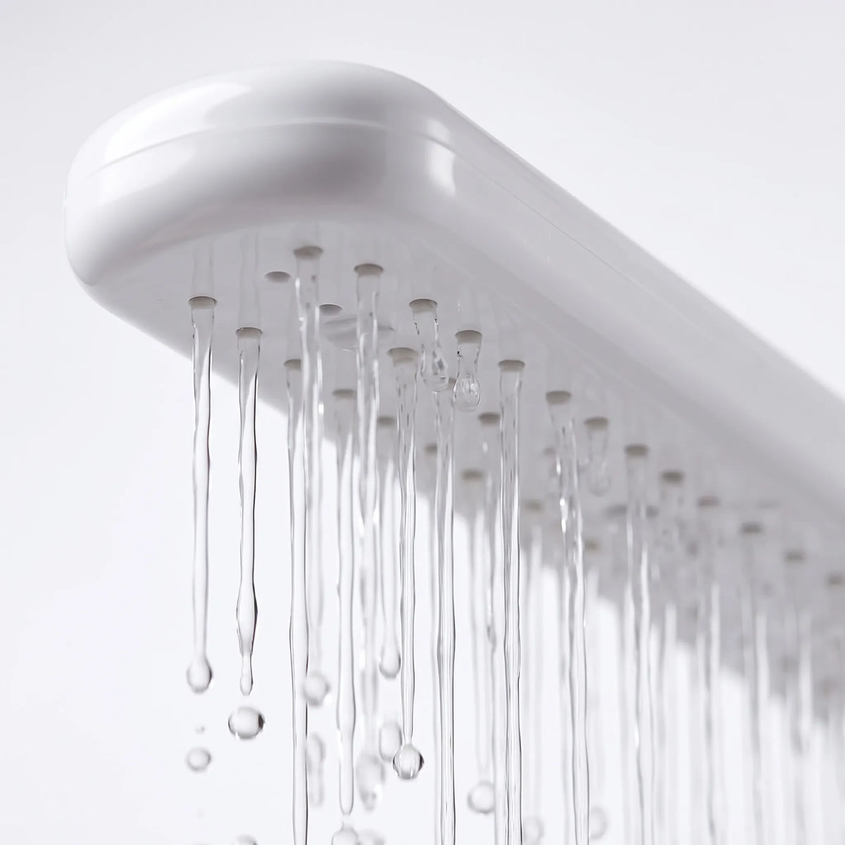 Close-up of the underside of the white spray arm, showing the row of small outlets with thin streams of water running out. 3
