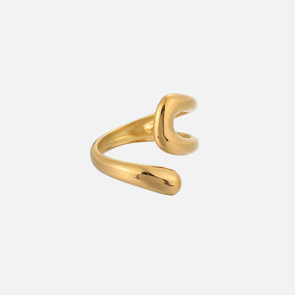 Side angle of the open gold-toned ring, showing its wrapped, tapering band and the curved loop opposite the rounded tip 2