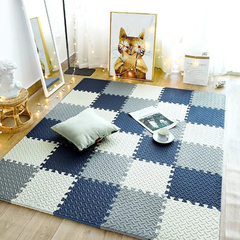 Interlocking foam tiles in navy, grey and cream laid as a chequered rug in a cosy room with a cushion and fairy lights. 1