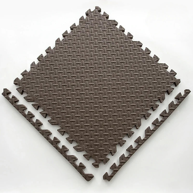 Single brown foam puzzle tile with an embossed leaf pattern, shown flat with two separate border edge pieces. 15