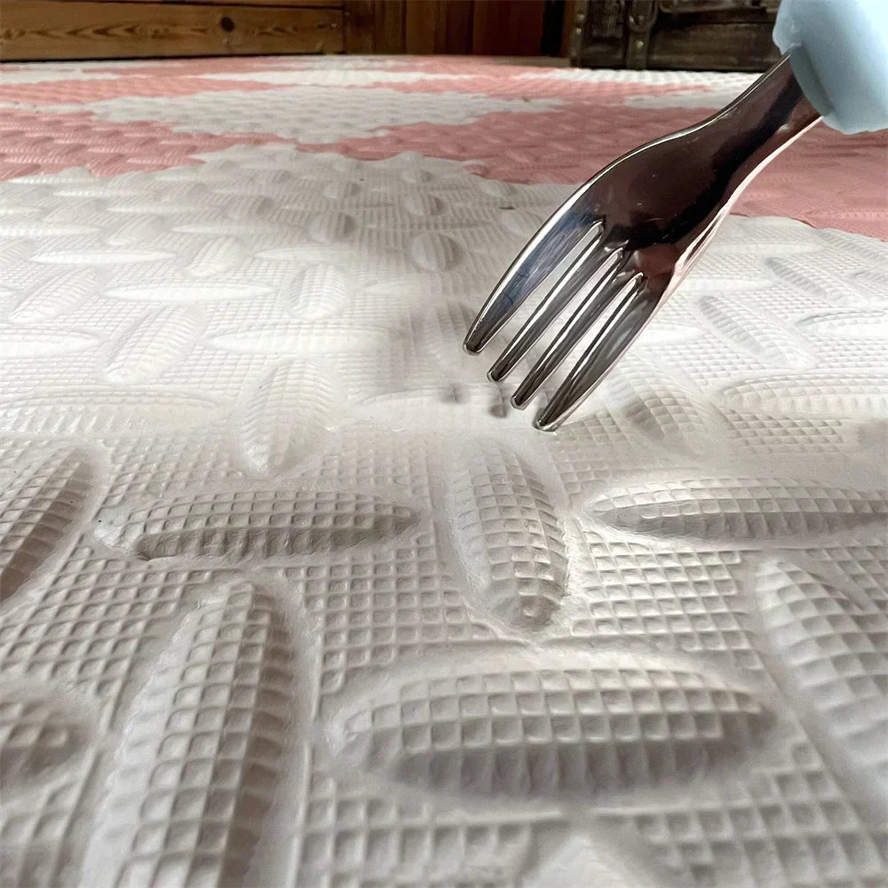 Close-up of the embossed leaf texture on a cream foam tile, with a fork pressing into the soft surface. 5