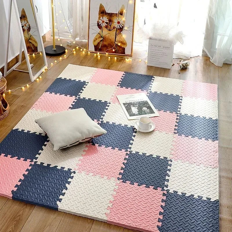 Foam tile mat in pink, navy and cream squares on a wooden floor with a cushion, a cup and a magazine. 6