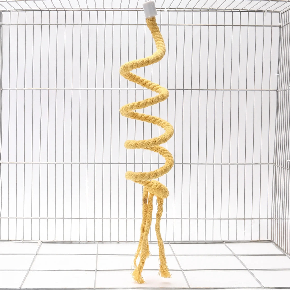 Yellow spiral rope perch hanging in an empty wire cage, with knot and loose frayed tassels at the bottom. 4