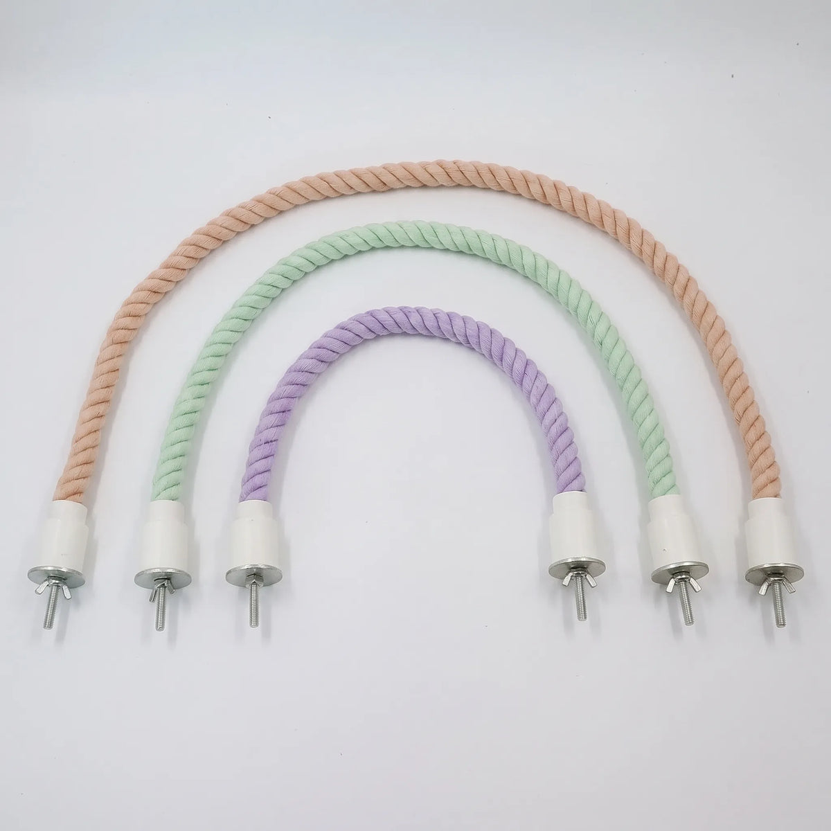 Three twisted cotton rope perches in peach, mint green and lilac, arranged as nested arches by size, each with white end caps and wing-nut bolts. 1