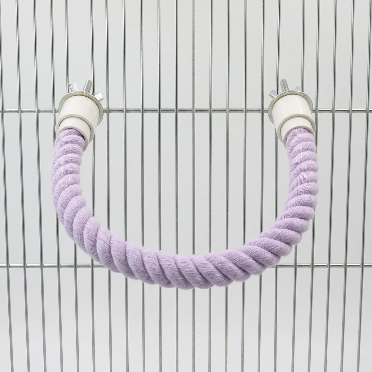 Lilac rope perch bent into a U shape and bolted to the bars of a metal cage. 5