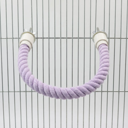 Lilac rope perch bent into a U shape and bolted to the bars of a metal cage. 5