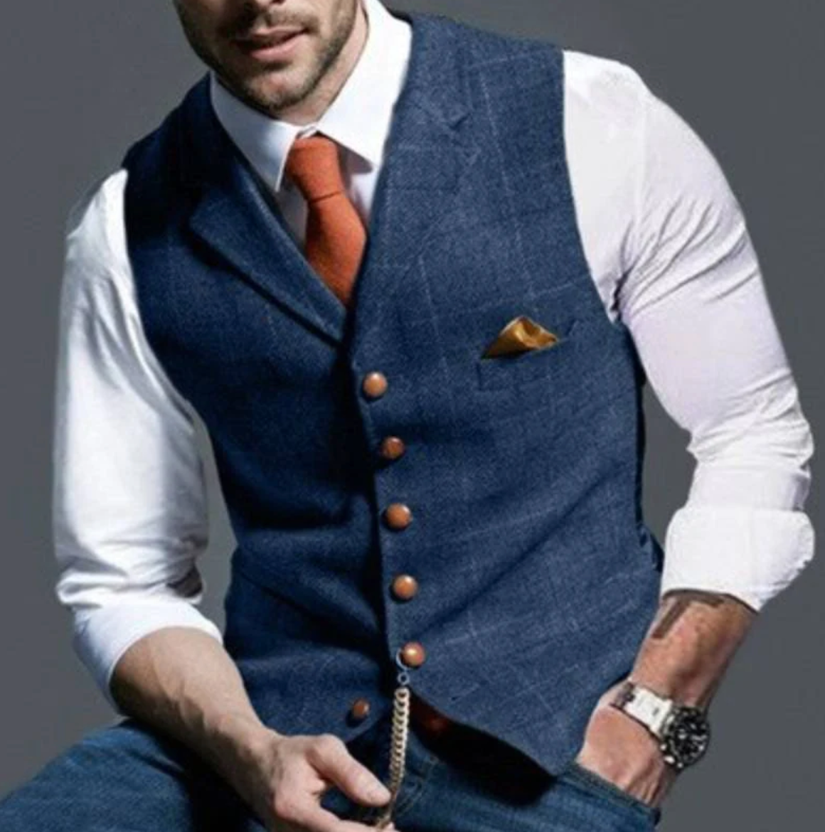 Model wearing the waistcoat in navy blue tweed with a white shirt and orange tie 1
