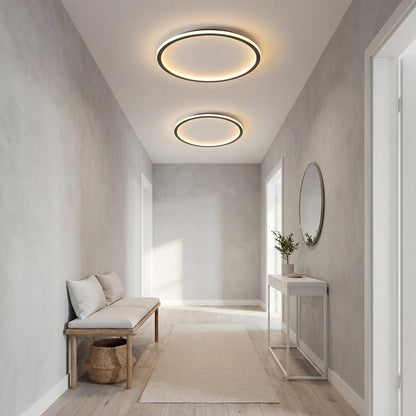 Two ring lights of different sizes lit along a narrow entrance hall with a bench, console table and round mirror. 6