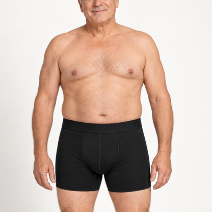 Older male model standing front-on, shirtless, wearing black boxer briefs that sit at the waist and cover the upper thigh. 2