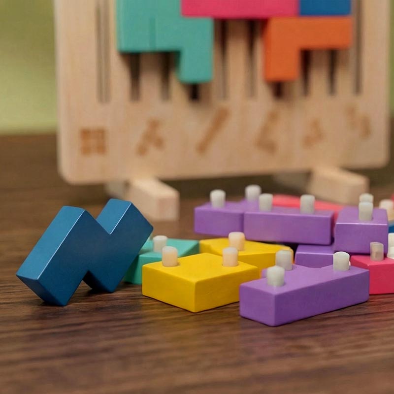 Close-up of loose blocks with small white pegs on their undersides, in front of the upright board with its engraved shape symbols. 5