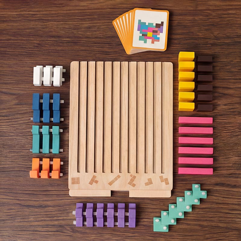 Flat lay on a wooden table of the slotted board, a fan of pattern cards and the coloured blocks sorted by colour. 2