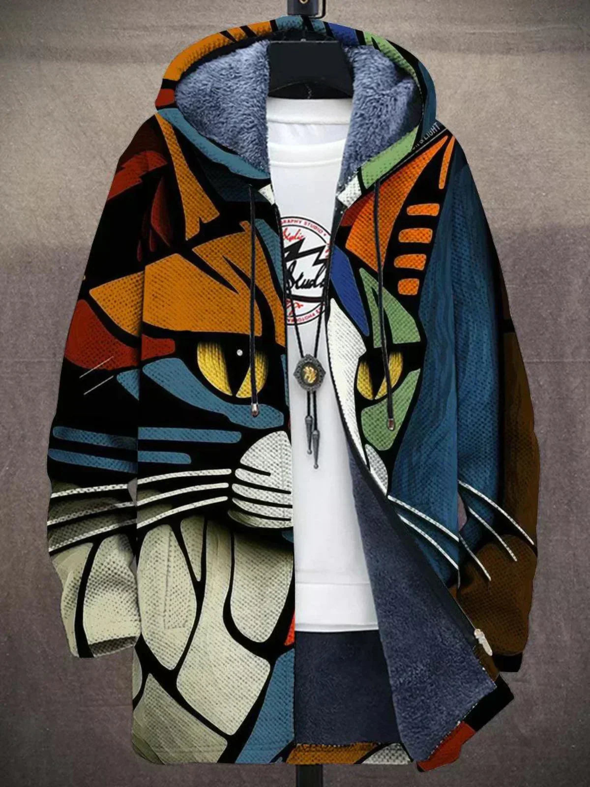 Hooded cardigan printed with a bold abstract cat face with yellow eyes, partly unzipped over a white top 4
