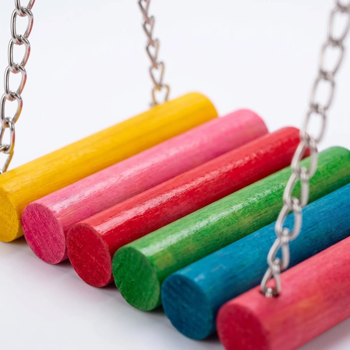 Close-up of the swing's rainbow-coloured wooden dowels and the metal chains attached to them, against a plain white background. 3