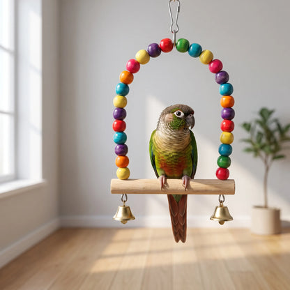 Green-cheeked conure sitting on the wooden perch of the swing, with a wooden floor and window in the background. 3