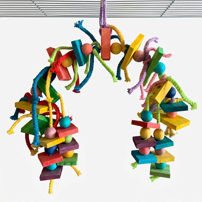 Toy hanging in an arch from a cage roof, with dyed wooden blocks, beads, knotted cotton ropes and small bells. 1