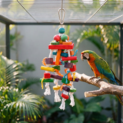 Toy hanging inside an aviary among palm plants, with a green, orange and blue parrot perched on a branch beside it. 2