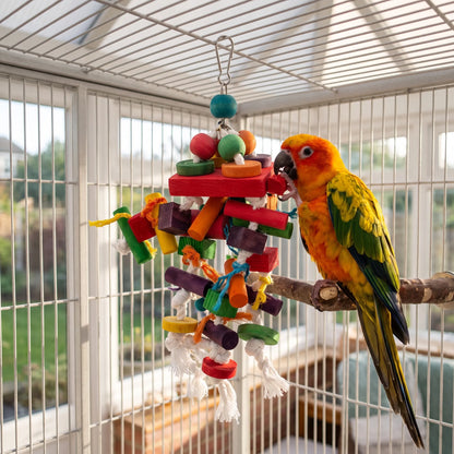 A yellow and orange parrot perched in a cage, chewing a red wooden block on the toy hanging beside it. 3