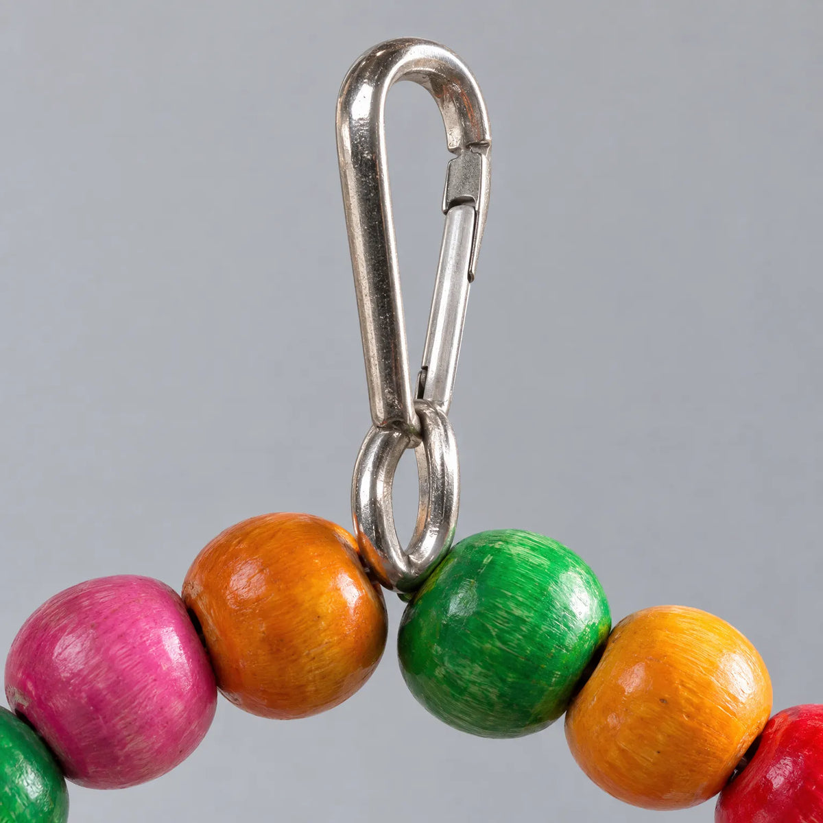 Close-up of the metal clip and ring joining the coloured wooden beads at the top of the arch swing. 4
