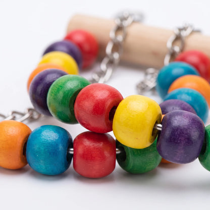 Close-up of the glossy, brightly dyed wooden beads strung on metal, with a chain and a plain wooden perch behind. 4