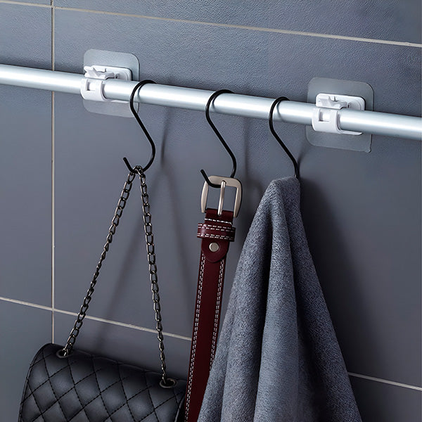 Rod fixed to a tiled wall by two clips, with black S-hooks holding a chain-strap handbag, a leather belt and a grey towel. 5