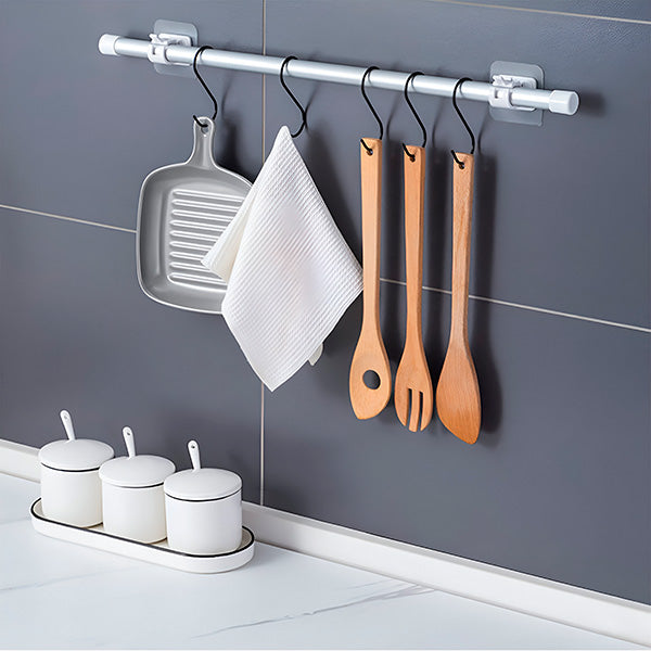 Kitchen wall rod on two clips with S-hooks holding a grill pan, a white cloth and three wooden utensils. 6