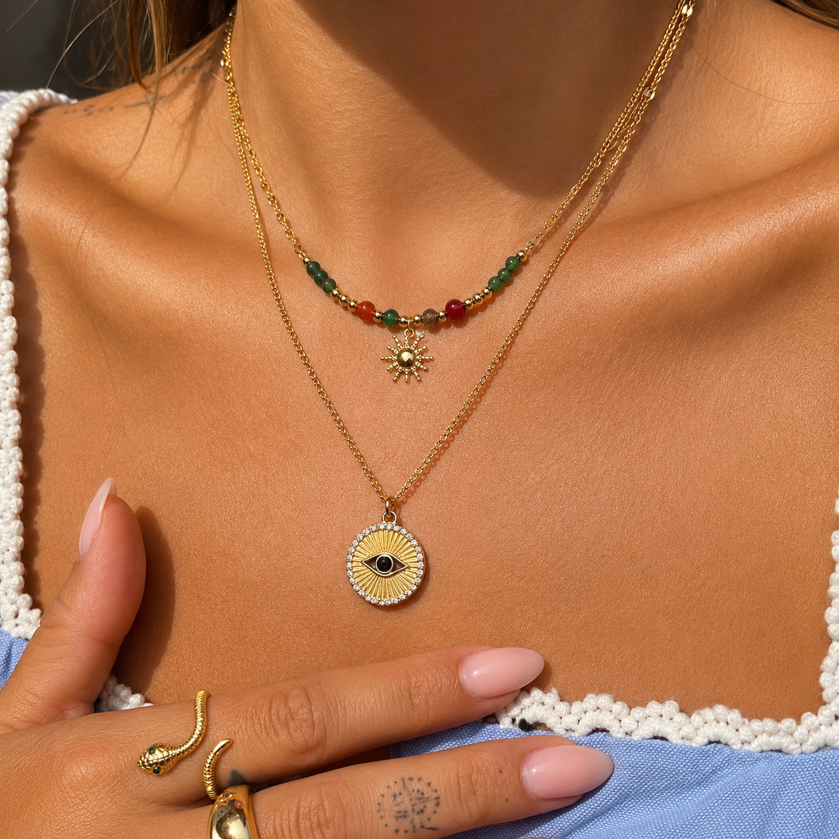 Necklace worn by a model, layered above a longer gold chain with a round eye pendant 3