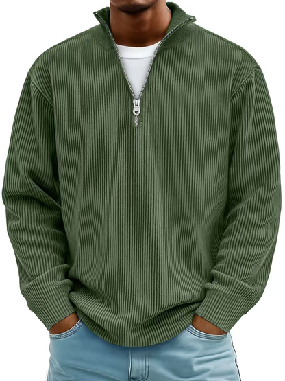 Man wearing the half-zip ribbed jumper in olive green over a white tee, hands in jeans pockets 8