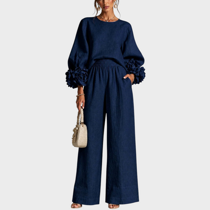 Model wearing the navy blue set, front view, with rose cuffs and wide-leg trousers 2