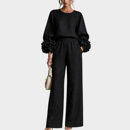 Model in the black set, front view, showing the rose-trimmed sleeves and high elasticated waist 3