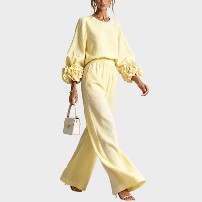 Model walking in the pale yellow set, with large fabric roses on the sleeve cuffs 7