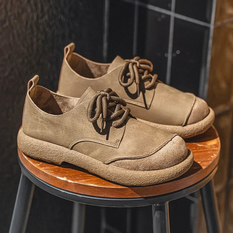 Tan lace-up shoes with thick crepe-style soles resting on a round wooden stool 3