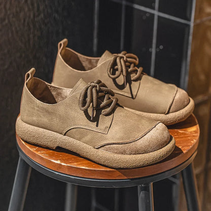 Tan lace-up shoes with thick crepe-style soles resting on a round wooden stool 3