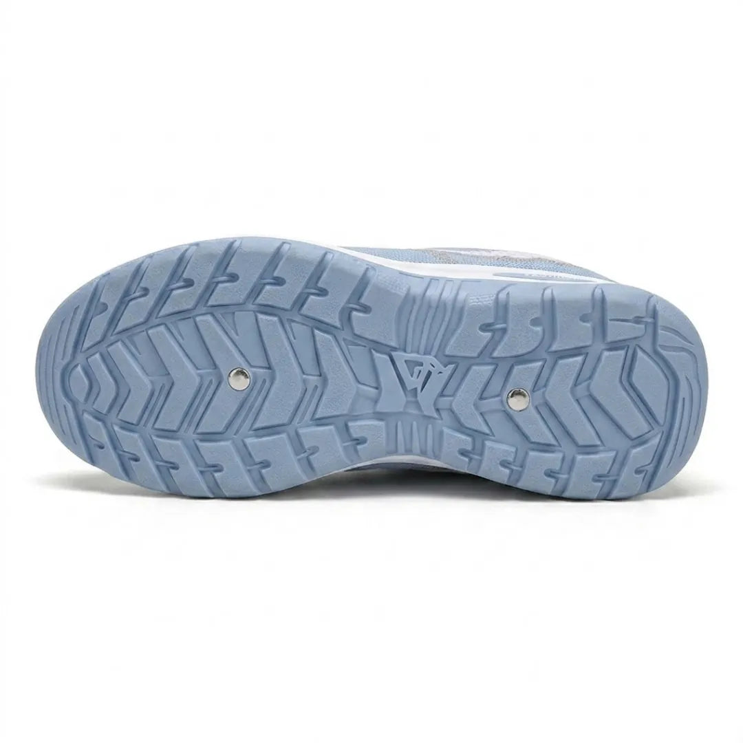 Underside of the pale blue trainer showing the deep, patterned tread of the rubber outsole with two small metal studs. 9