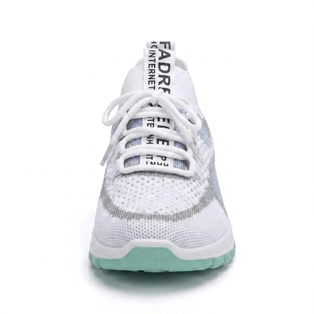 Front view of a white mesh trainer with a mint green sole, showing the laces, tongue tab and rounded toe. 17