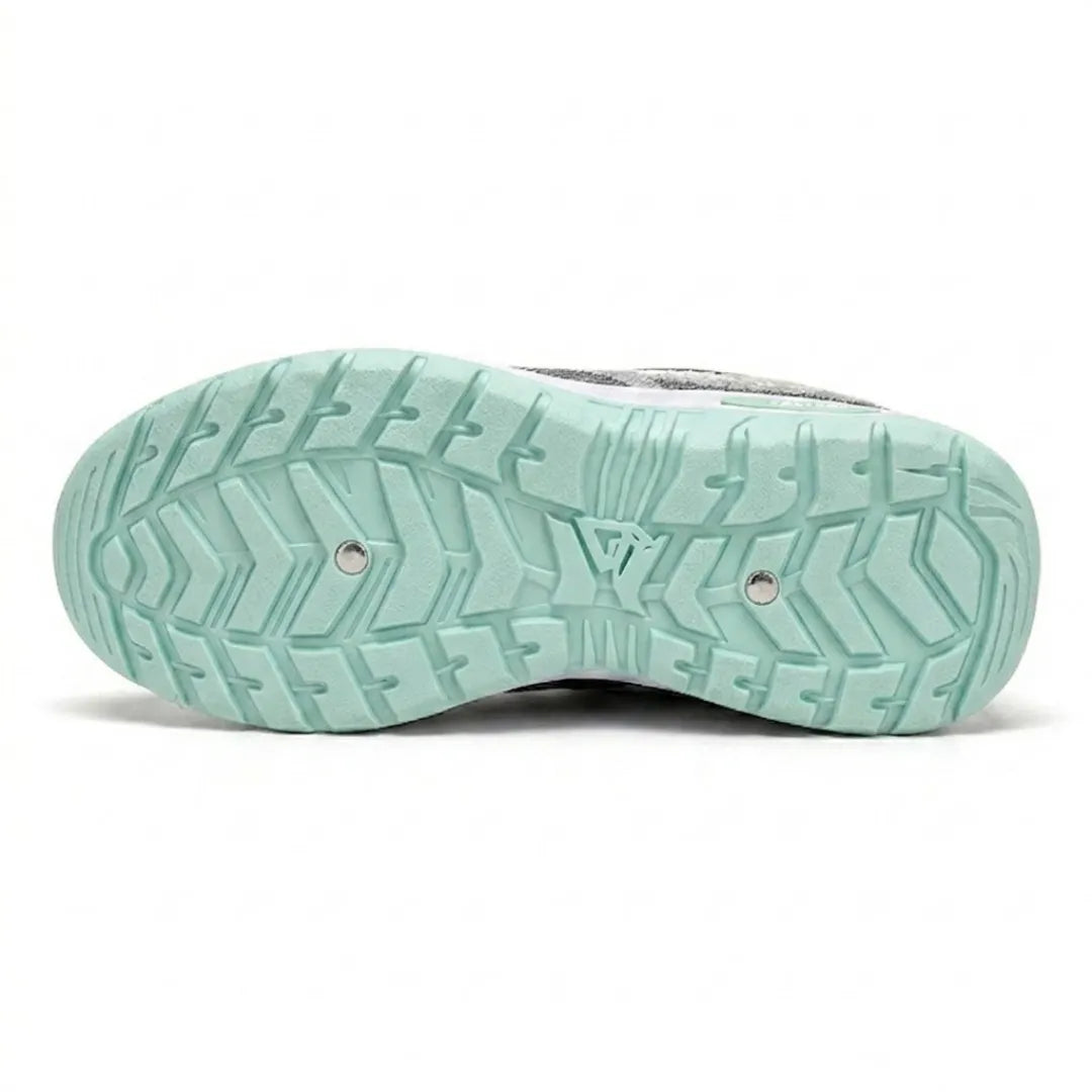 Underside of the mint green trainer showing the deep, patterned tread of the rubber outsole with two small metal studs. 18