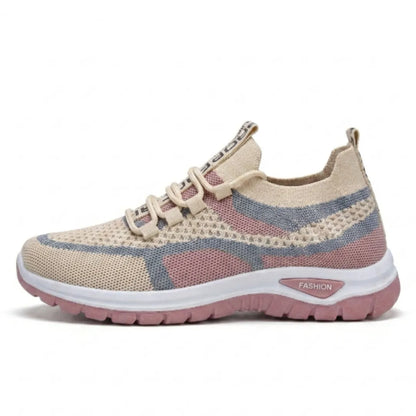 Side view of a single beige, pink and grey mesh trainer with a white midsole and pink outsole. 28