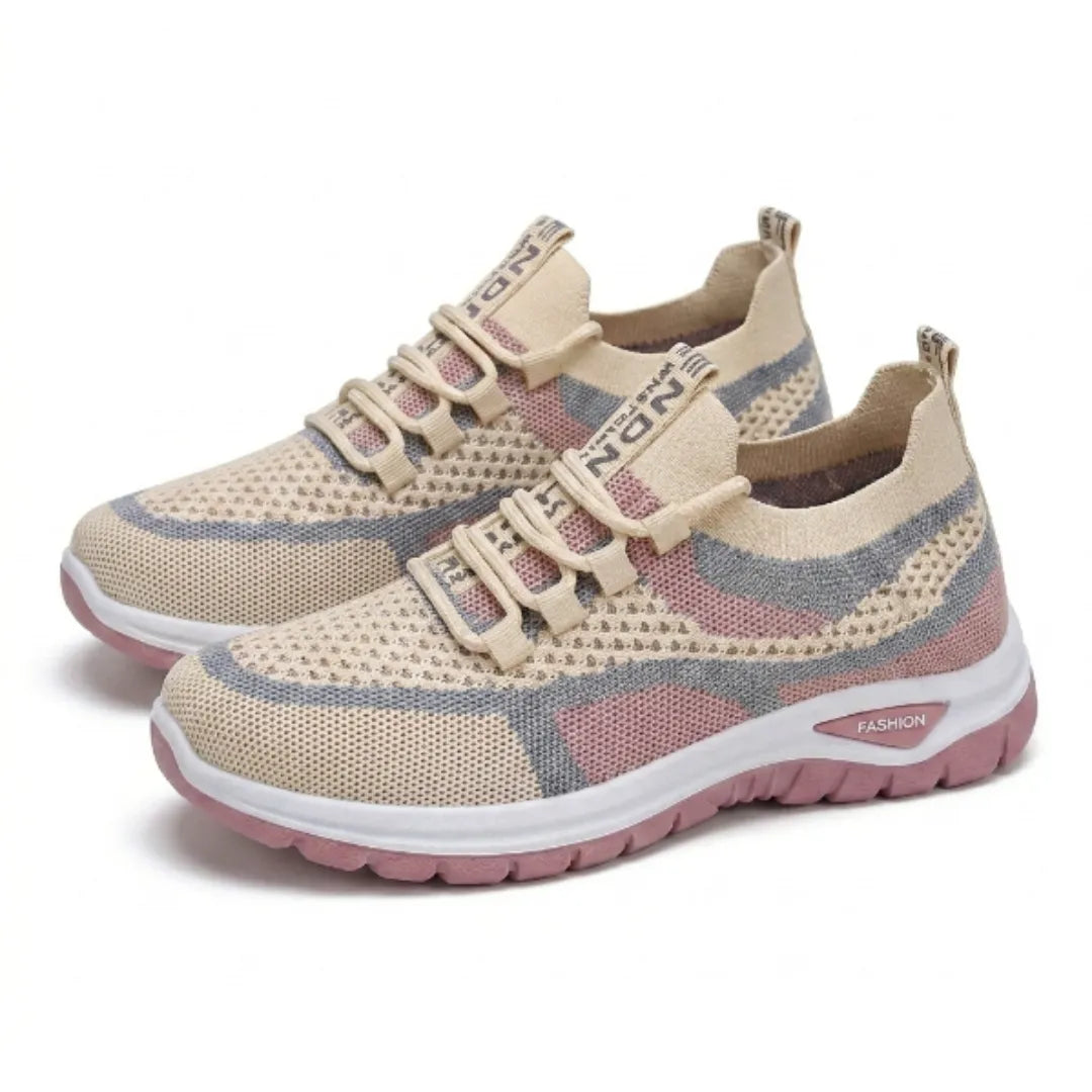 Pair of beige, pink and grey mesh trainers with elasticated laces and a white and pink sole, seen at an angle. 34