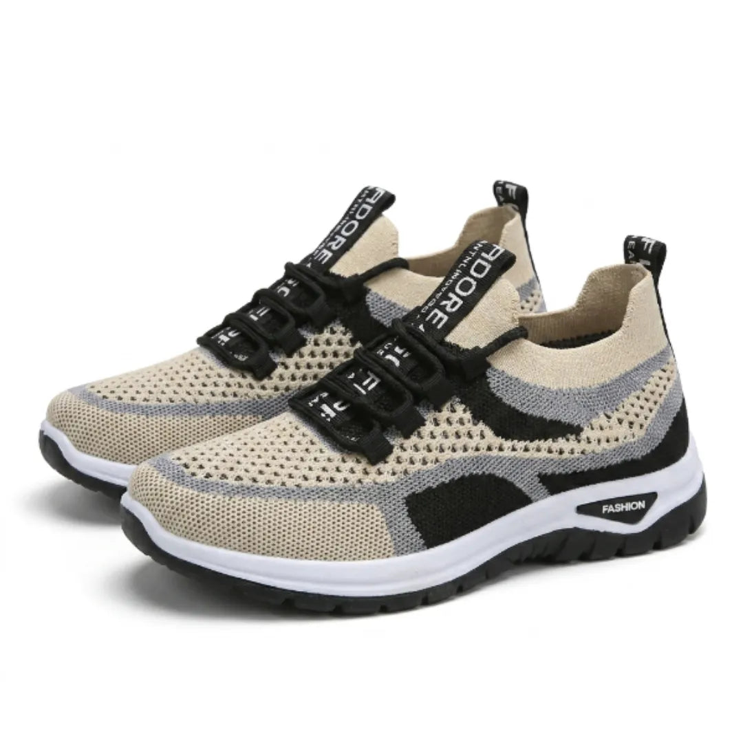 Pair of beige knitted mesh trainers with black and grey accents, black laces and white-and-black soles, shown from a three-quarter angle. 43