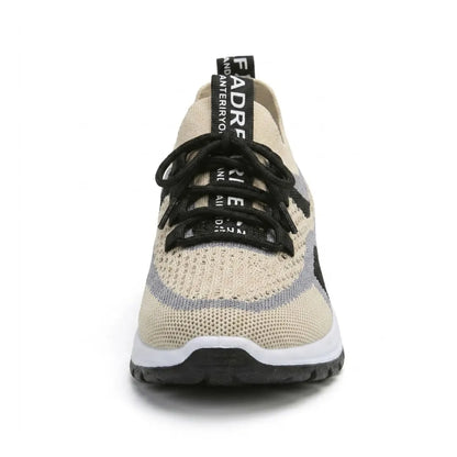 Front view of a beige breathable mesh trainer with black laces, grey and black side panels and a chunky white sole. 44