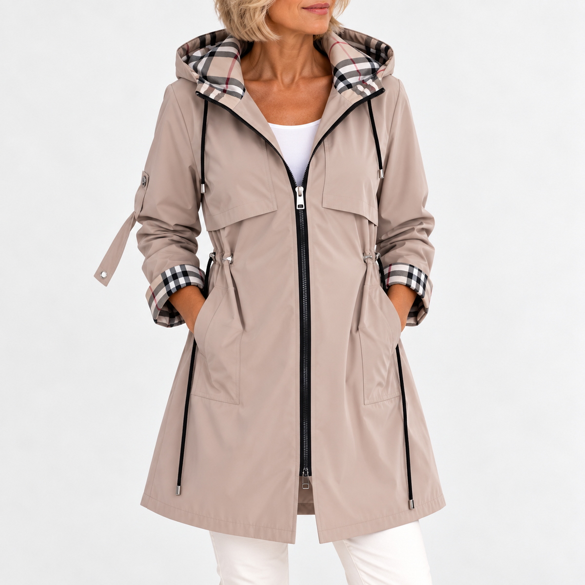 Front view of the coat in beige on a model, hands in pockets, showing the drawcord waist and check-lined hood. 2