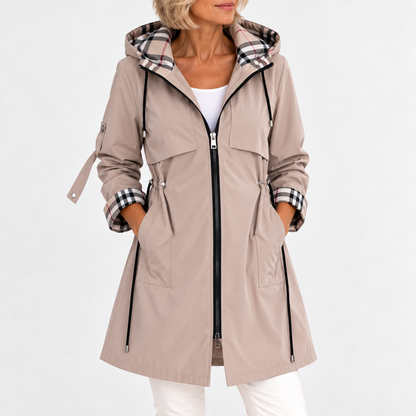 Front view of the coat in beige on a model, hands in pockets, showing the drawcord waist and check-lined hood. 2