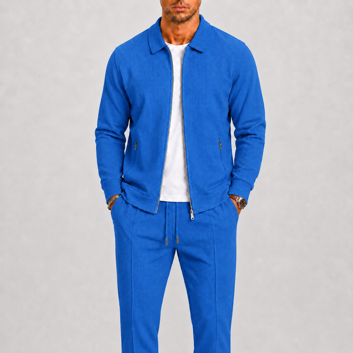 Model wears the textured zip jacket and trousers in bright blue over a white t-shirt 5