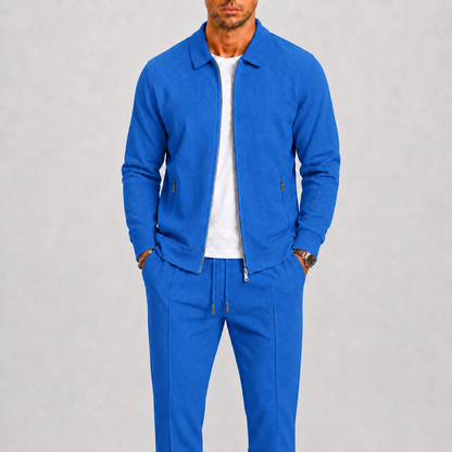 Model wears the textured zip jacket and trousers in bright blue over a white t-shirt 5